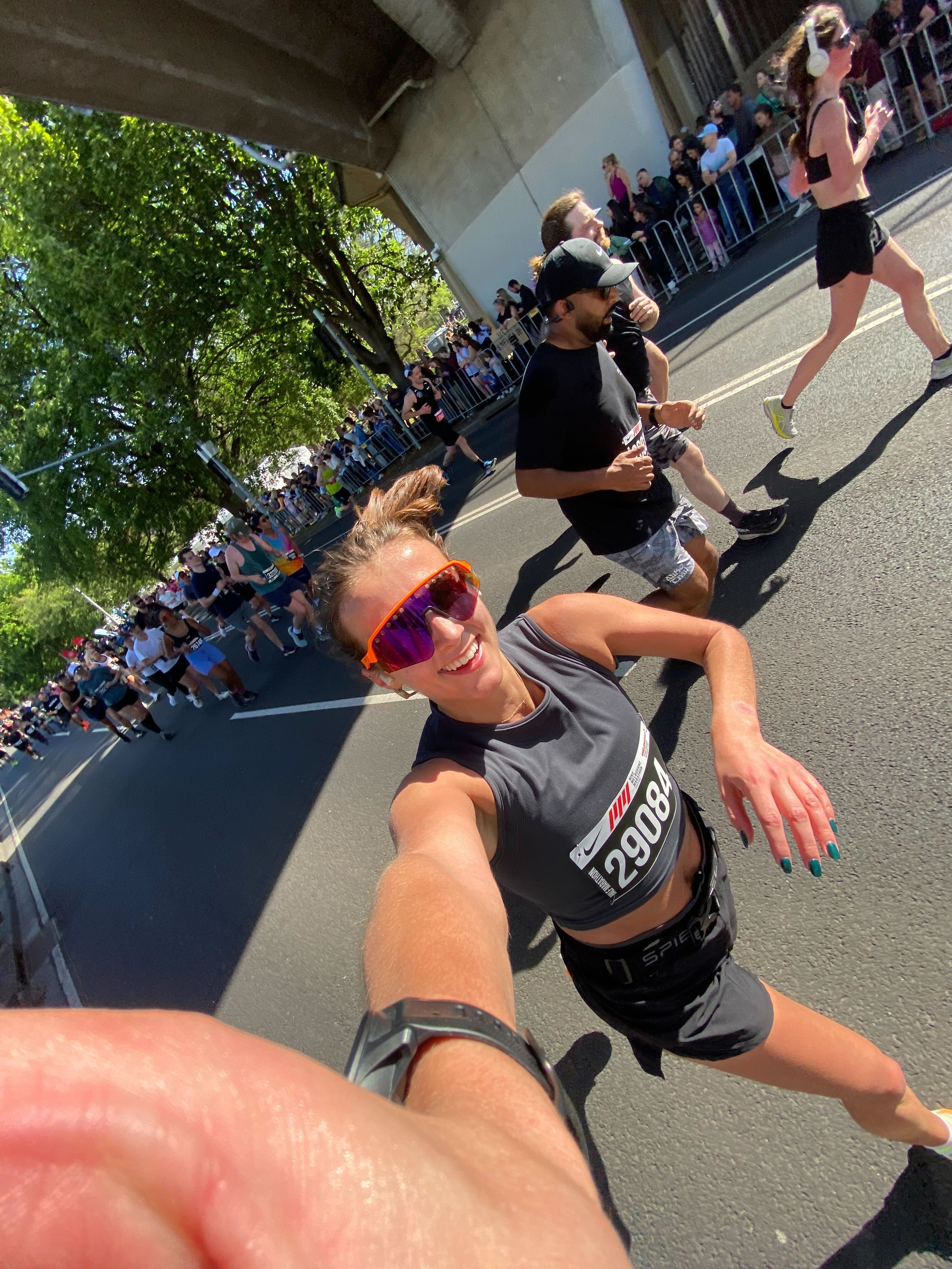 A picture showing Jess smiling and running at the Melbourne Half Marathon.